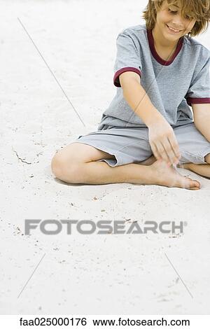 Boy playing in sand, smiling, cropped view View Large Photo Image Stock Photograph - Boy playing in sand, smiling, cropped view. Fotosearch