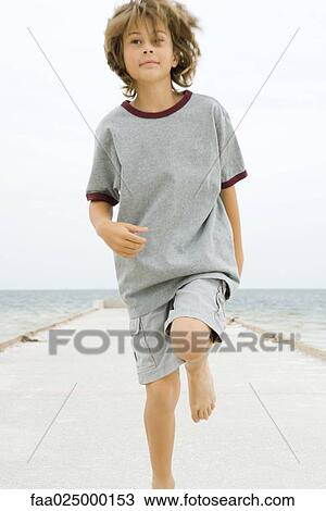 Boy running on pier, looking away, close-up View Large Photo Image Stock Image - Boy running on pier, looking away, close-up. Fotosearch