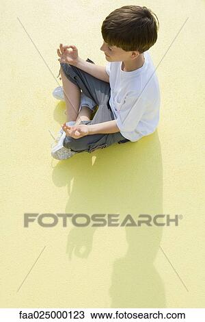 Boy sitting in lotus position, high angle view View Large Photo Image Stock Image - Boy sitting in lotus position, high angle view. Fotosearch