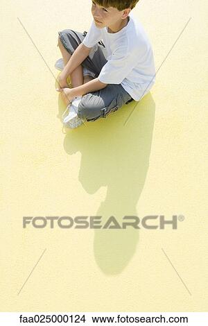 Boy sitting indian style on the ground, high angle view View Large Photo Image Picture - Boy sitting indian style on the ground, high angle view. Fotosearch