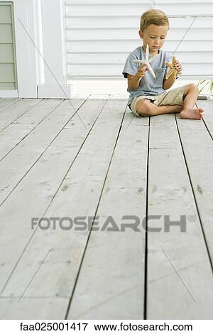 Boy sitting on the ground, holding starfish in each hand View Large Photo Image Stock Photo - Boy sitting on the ground, holding starfish in each hand. Fotosearch