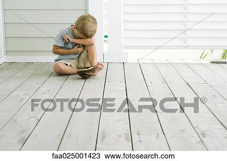 Boy sitting on the ground next to bird's nest, holding eggs in his hands, head resting on arm View Large Photo Image Stock Image - Boy sitting on the ground next to bird's nest, holding eggs in his hands, head resting on arm. Fotosearch