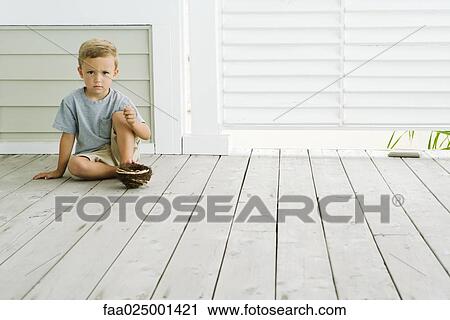Boy sitting on the ground with bird's nest under his foot, frowning at camera View Large Photo Image Stock Image - Boy sitting on the ground with bird's nest under his foot, frowning at camera. Fotosearch