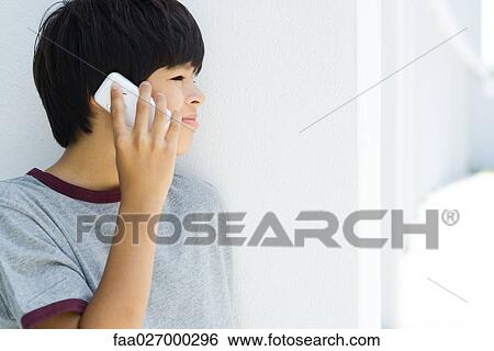 Boy using cell phone, looking away View Large Photo Image Stock Photograph - Boy using cell phone, looking away. Fotosearch