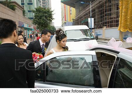 Bride and groom getting in to car View Large Photo Image Stock Image - Bride and groom getting in to car. Fotosearch