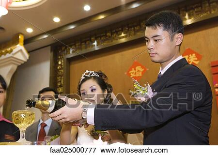 Bride and groom pouring champagne together at reception View Large Photo Image Stock Photo - Bride and groom pouring champagne together at reception. Fotosearch