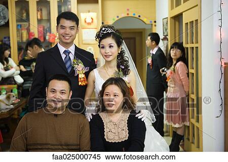 Bride and groom standing behind couple, smiling, portrait View Large Photo Image Stock Photography - Bride and groom standing behind couple, smiling, portrait. Fotosearch