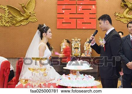 Bride and groom standing face to face, looking at each other, groom speaking into microphone View Large Photo Image Stock Image - Bride and groom standing face to face, looking at each other, groom speaking into microphone. Fotosearch