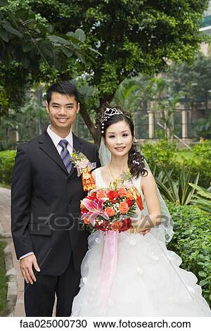 Bride and groom standing in verdant setting, portrait View Large Photo Image Stock Image - Bride and groom standing in verdant setting, portrait. Fotosearch
