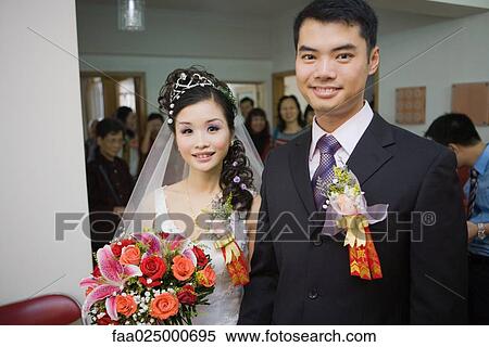 Bride and groom wearing corsages, smiling at camera, friends and family in background View Large Photo Image Stock Photography - Bride and groom wearing corsages, smiling at camera, friends and family in background. Fotosearch