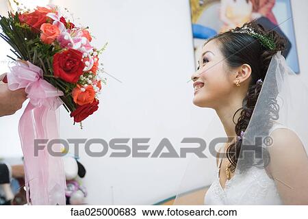 Bride being handed bouquet, cropped view View Large Photo Image Stock Image - Bride being handed bouquet, cropped view. Fotosearch