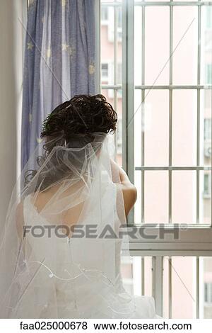 Stock Photo - Bride facing window, rear view. Fotosearch