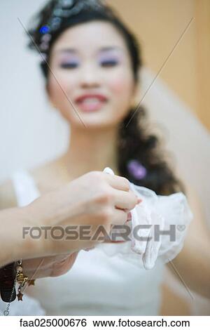 Bride having lace glove put on, cropped view View Large Photo Image Stock Photograph - Bride having lace glove put on, cropped view. Fotosearch