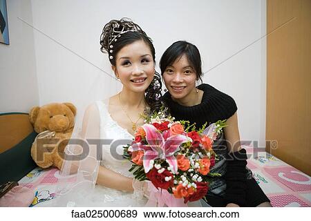 Bride sitting on bed with female friend, smiling, portrait View Large Photo Image Stock Photo - Bride sitting on bed with female friend, smiling, portrait. Fotosearch