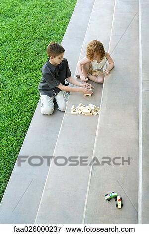 Brother and sister playing with blocks on steps, high angle view View Large Photo Image Stock Photo - Brother and sister playing with blocks on steps, high angle view. Fotosearch