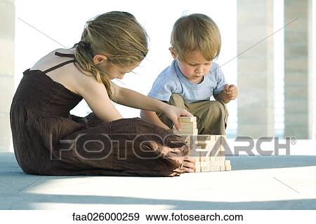 Brother and sister sitting on the ground, stacking building blocks together View Large Photo Image Stock Photo - Brother and sister sitting on the ground, stacking building blocks together. Fotosearch