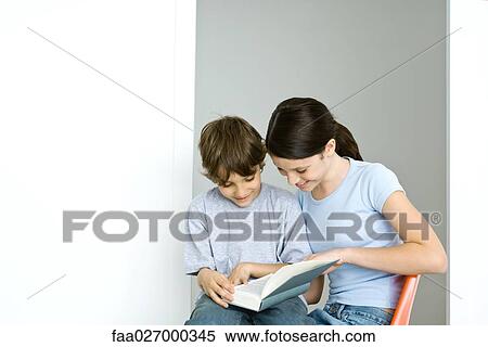 Brother and sister sitting, reading book together, both smiling View Large Photo Image Stock Photography - Brother and sister sitting, reading book together, both smiling. Fotosearch