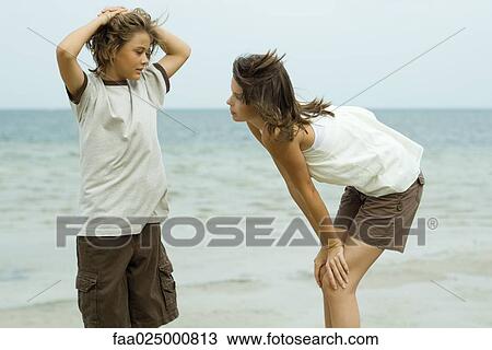 Brother and sister standing face to face at the beach, boy with hands behind head View Large Photo Image Stock Image - Brother and sister standing face to face at the beach, boy with hands behind head. Fotosearch