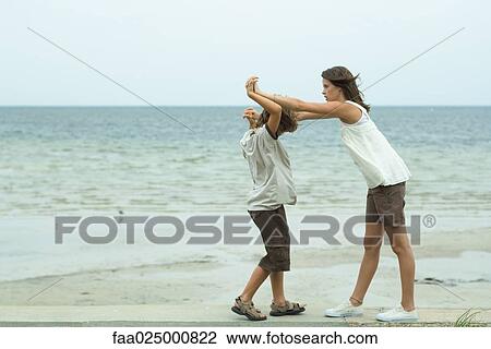 Brother and sister standing face to face at the beach with clasped hands View Large Photo Image Stock Image - Brother and sister standing face to face at the beach with clasped hands. Fotosearch