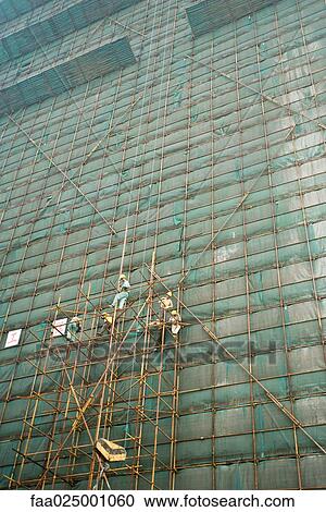 Stock Image - Building undergoing renovation, workers on scaffolding. Fotosearch