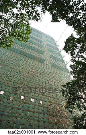 Stock Image - Building undergoing renovation, workers on scaffolding. Fotosearch