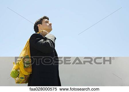 Businessman carrying groceries over shoulder View Large Photo Image Stock Photography - Businessman carrying groceries over shoulder. Fotosearch