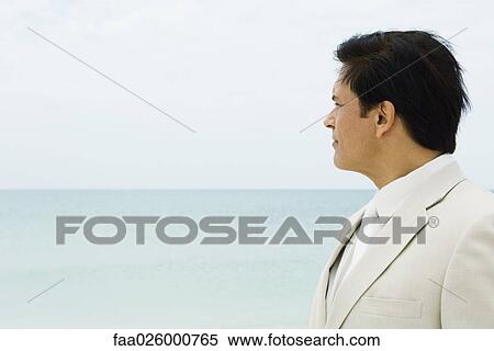 Businessman, looking at distance, sea in background View Large Photo Image Stock Photography - Businessman, looking at distance, sea in background. Fotosearch