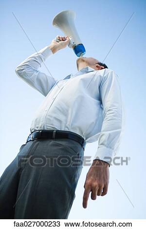 Businessman shouting into megaphone, low angle view View Large Photo Image Stock Image - Businessman shouting into megaphone, low angle view. Fotosearch