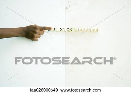 Child knocking over line of dominoes, cropped view of hand View Large Photo Image Stock Photo - Child knocking over line of dominoes, cropped view of hand. Fotosearch