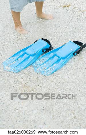 Child standing next to flippers on sand, cropped view View Large Photo Image Stock Photo - Child standing next to flippers on sand, cropped view. Fotosearch