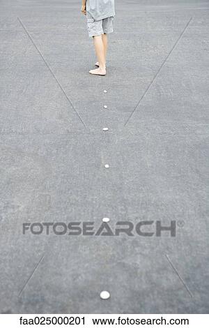 Child walking along line of pebbles, cropped rear view View Large Photo Image Stock Image - Child walking along line of pebbles, cropped rear view. Fotosearch
