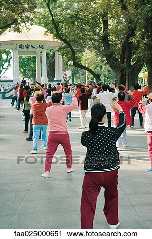 China, large group of adults doing Tai Chi Chuan in city square, rear view View Large Photo Image Stock Image - China, large group of adults doing Tai Chi Chuan in city square, rear view. Fotosearch