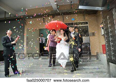 Chinese wedding, bride and groom leaving under confetti, bride covered by red parasol View Large Photo Image Stock Photo - Chinese wedding, bride and groom leaving under confetti, bride covered by red parasol. Fotosearch