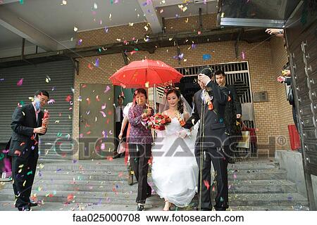 Chinese wedding, bride and groom leaving under confetti, bride covered by red parasol View Large Photo Image Stock Photo - Chinese wedding, bride and groom leaving under confetti, bride covered by red parasol. Fotosearch