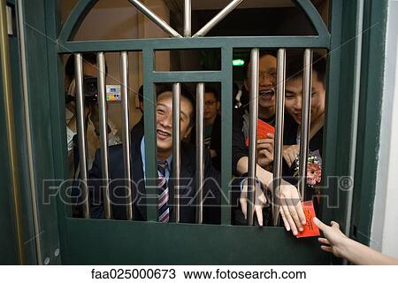 Chinese wedding door tradition, men looking through barred door, holding gift envelopes, laughing and smiling View Large Photo Image Stock Image - Chinese wedding door tradition, men looking through barred door, holding gift envelopes, laughing and smiling. Fotosearch