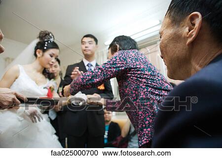 Stock Image - Chinese wedding tea ceremony, focus on senior man in foreground. Fotosearch