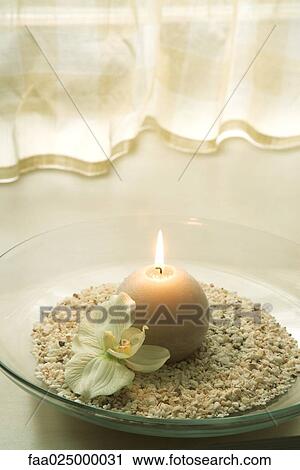 Close-up of burning candle in bowl next to orchid flower View Large Photo Image Stock Image - Close-up of burning candle in bowl next to orchid flower. Fotosearch