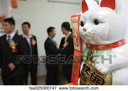 Close-up of Maneki Neko figurine, people standing in background View Large Photo Image Stock Photo - Close-up of Maneki Neko figurine, people standing in background. Fotosearch