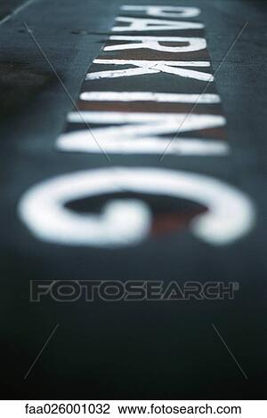 Stock Image - Close-up of the word "parking" on pavement, selective focus. Fotosearch