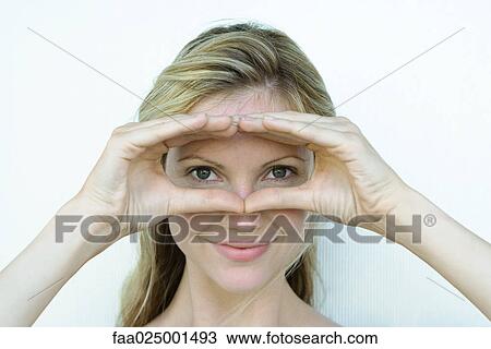 Stock Image - close-up, smiling, head, woman, shading eyes, looking through. Fotosearch