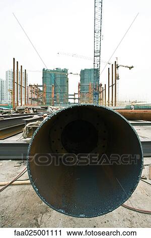 Construction site, end of metal pipe in foreground View Large Photo Image Stock Image - Construction site, end of metal pipe in foreground. Fotosearch