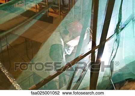 Construction worker behind safety net View Large Photo Image Stock Image - Construction worker behind safety net. Fotosearch