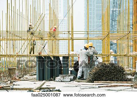 Construction workers working at construction site View Large Photo Image Stock Photo - Construction workers working at construction site. Fotosearch