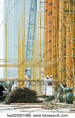 Construction workers working at construction site View Large Photo Image Stock Photo - Construction workers working at construction site. Fotosearch