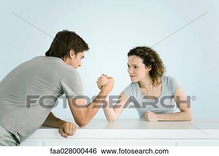 Couple arm wrestling together View Large Photo Image Stock Photograph - Couple arm wrestling together. Fotosearch
