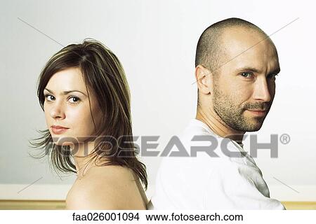 Couple back to back, both looking over shoulders at camera View Large Photo Image Picture - Couple back to back, both looking over shoulders at camera. Fotosearch