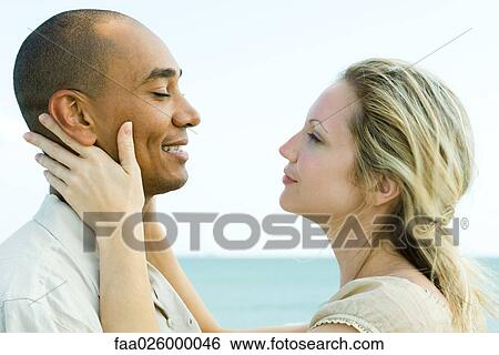 Couple face to face, woman holding man's neck, side view View Large Photo Image Stock Photograph - Couple face to face, woman holding man's neck, side view. Fotosearch