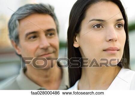Couple looking away, focus on woman in foreground View Large Photo Image Stock Photograph - Couple looking away, focus on woman in foreground. Fotosearch
