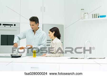 Couple preparing meal together in kitchen View Large Photo Image Picture - Couple preparing meal together in kitchen. Fotosearch