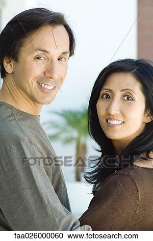 Couple smiling over their shoulders at camera, portrait View Large Photo Image Stock Image - Couple smiling over their shoulders at camera, portrait. Fotosearch